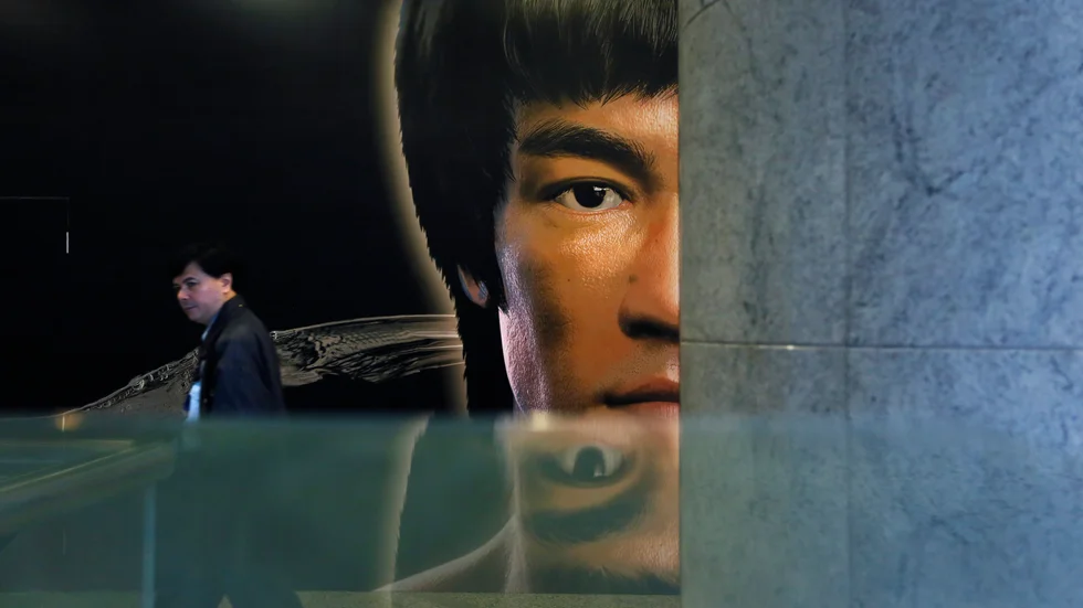 En man går förbi en poster för Bruce Lees museum i Hongkong. Staden har nyligen skärpt sina censurlagar för film, en konstform som varit stor och viktig i Hongkong. Arkivbild.