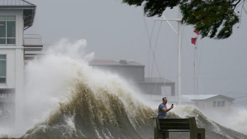 En man tar en selfie medan höga vågor slår mot flodmynningen Lake Pontchartrain i sydöstra Louisiana.