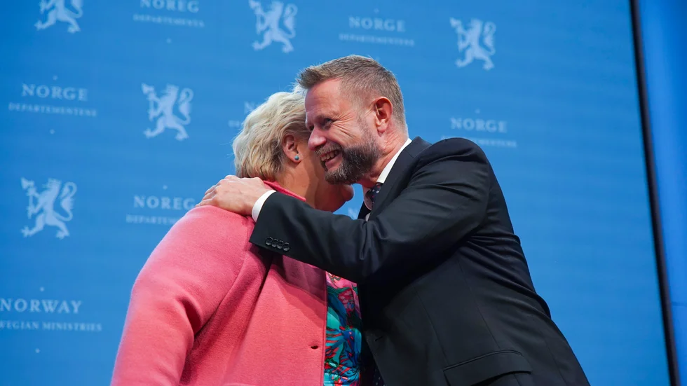 Förra statsministern Erna Solberg får en kram av förre hälsoministern Bent Høie vid en presskonferens om coronaviruset i september.