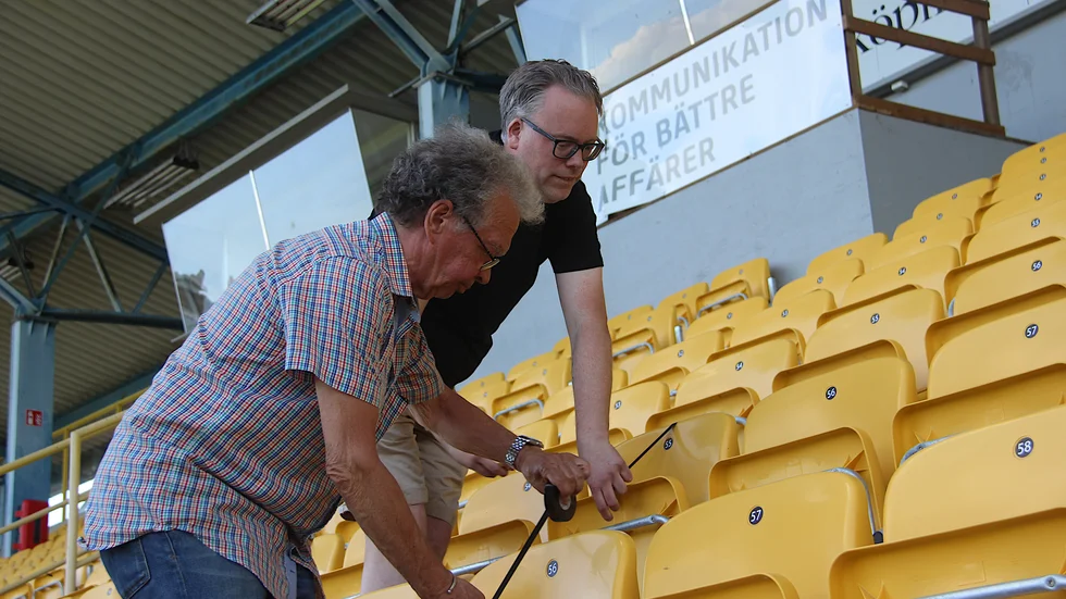 ESK-kassören Lasse Bengtsson och kanslisten Patrik Bolinder har det hektiskt just nu. Här tejpar de huvudläktaren för att publiken ska hålla avstånd.