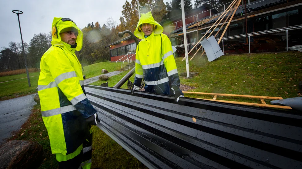 
Erik Jardviken och Peter Nilsson jobbar på i regnet med att montera nya plåtar på taket.
