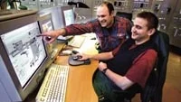 I värmeverkets kontrollcentral kan Jörgen Karlsson och Tommy Fridlund (närmast) via datorskärmar kontinuerligt övervaka processerna i verkets samtliga fyra pannor. Personal går här i skift dygnet runt. Foto: MAGNUS GLANS