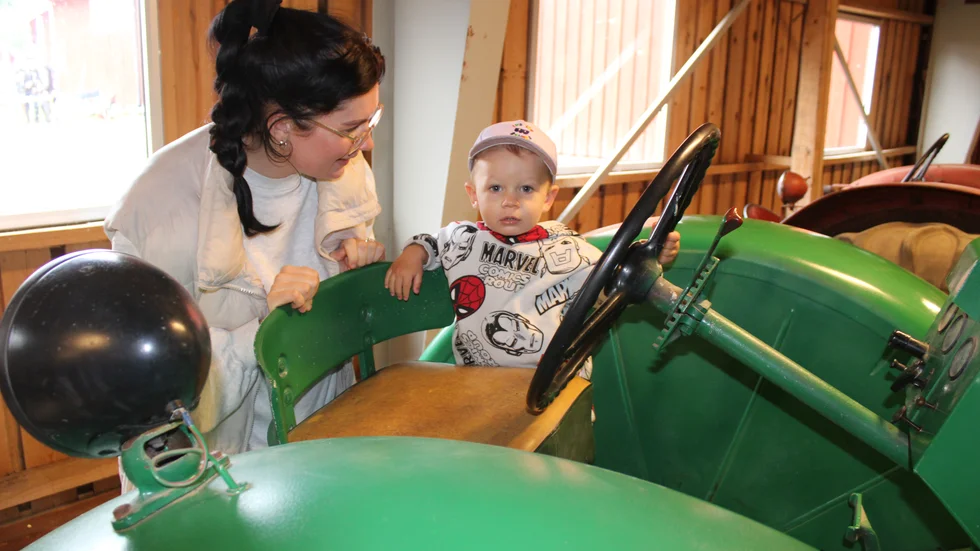 Miliam Jagerlöv, 1,5 år, fick kolla in en av veterantraktorerna på museet, med hjälp av mamma Moa Orre.