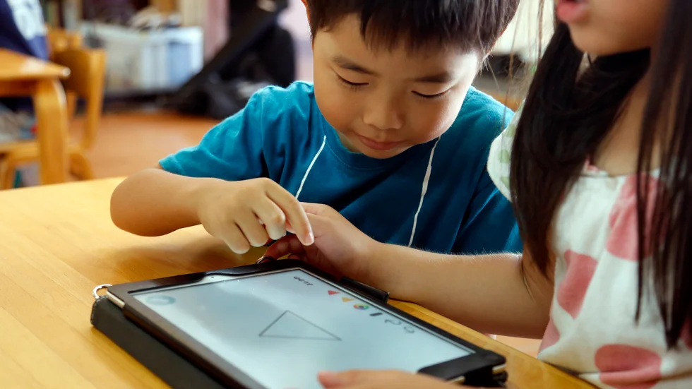 Japanska förskoleelever löser uppgifter på en läsplatta. De senaste åren har digitala verktyg införts på bred front i japanska skolor. Arkivbild.