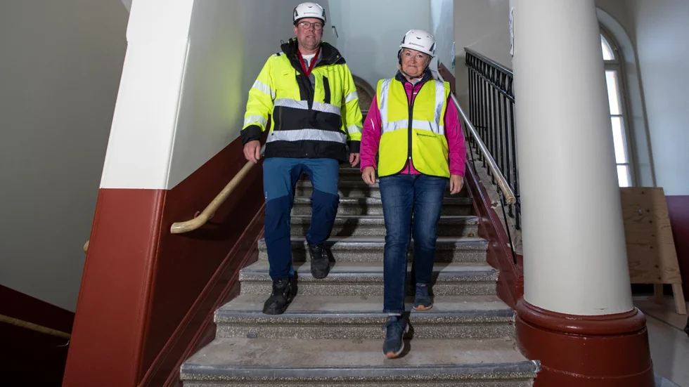 Projektkompaniets Mats Spång och samordnaren för skolprojektet i Vadstena, Suzanne Stråkander-Rockler, på väg nerför den nyrenoverade trappan i S:t Persskolans A-hus. Den röda färgen berättar Stråkander-Rockler är originalfärgen från 1850 som skrapats fram under en mängd lager av senare målningar. 