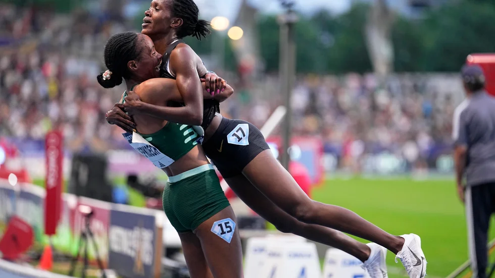 Faith Kipyegon, Kenya, hissas upp i luften av landsmaninnan Beatrice Chepkoech, till vänster, efter världsrekordet på 5|000 meter.