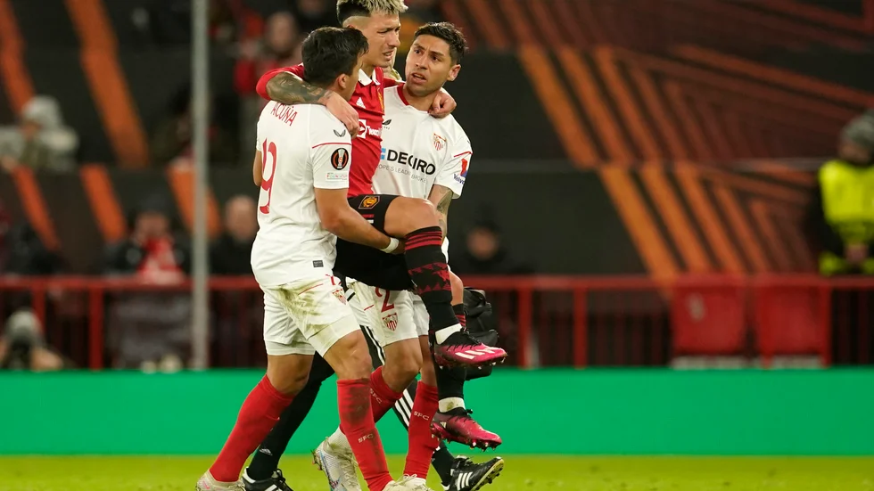Lisandro Martínez (i rött) bars ut av sina argentinska landslagskamrater Marcos Acuña (vänster) och Gonzalo Montiel (höger).