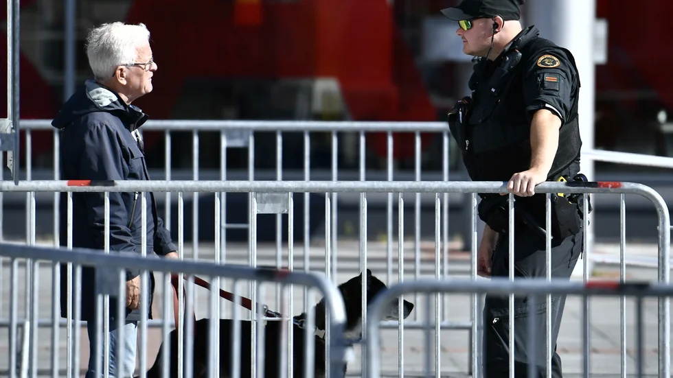 En finländsk polis talar med en man vid gränsövergången i Haparanda i augusti.
