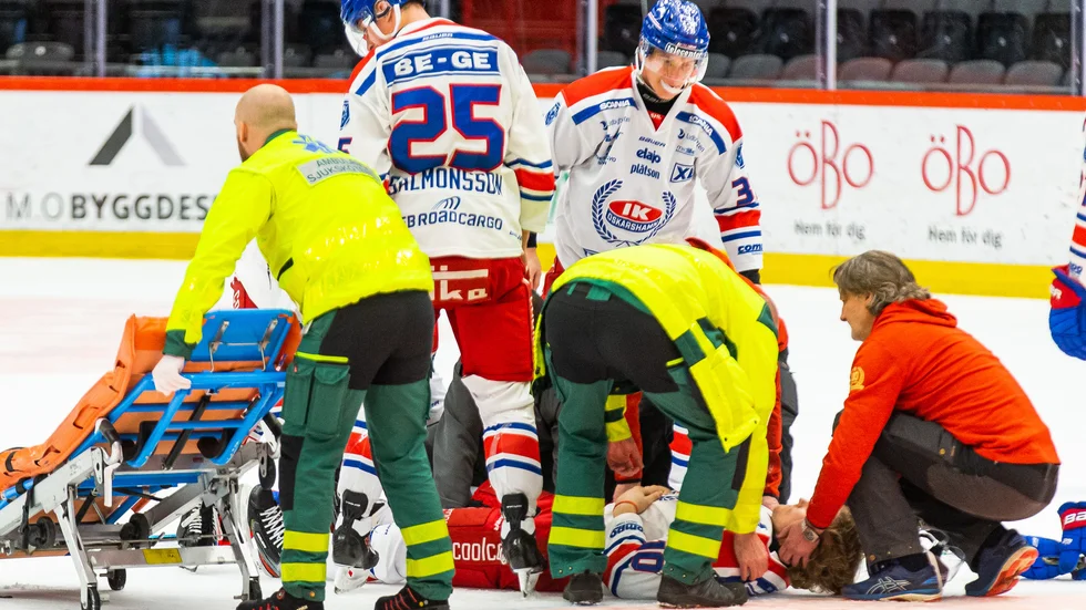 Oscar Sundh blir liggandes på isen och sedan utburen på bår efter tacklingen från Örebros Emil Larsson.  