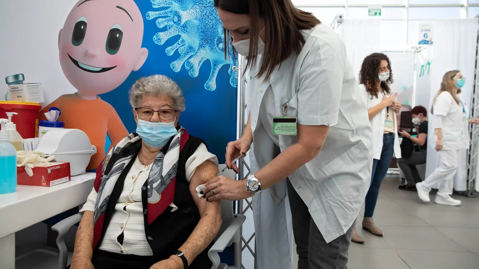 En israelisk kvinna får vaccin mot covid-19 på ett temporärt vaccinationscenter i Tel Aviv. Arkivbild