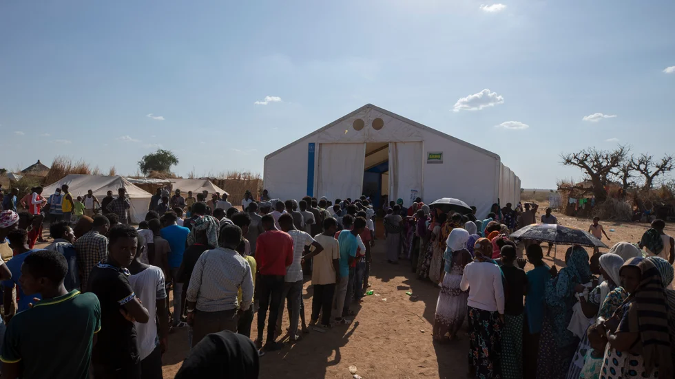 Tusentals människor flydde från Tigray i Etiopien när konflikten bröt ut i november. Här köar män och kvinnor för hjälp i ett flyktingläger i Sudan. Arkivbild.