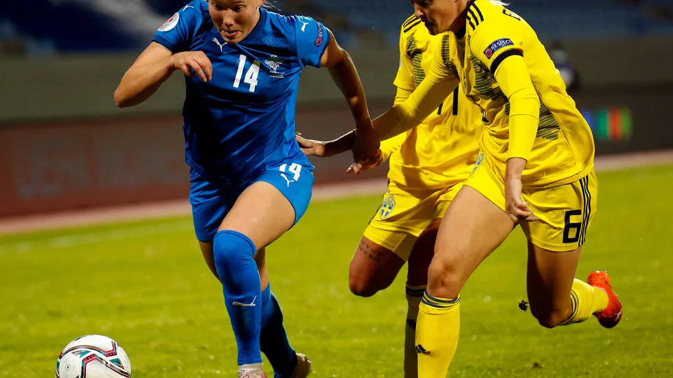 Hlin Eiriksdottir driver bollen i kamp med svenska mittbacksstjärnan Magdalena Eriksson.