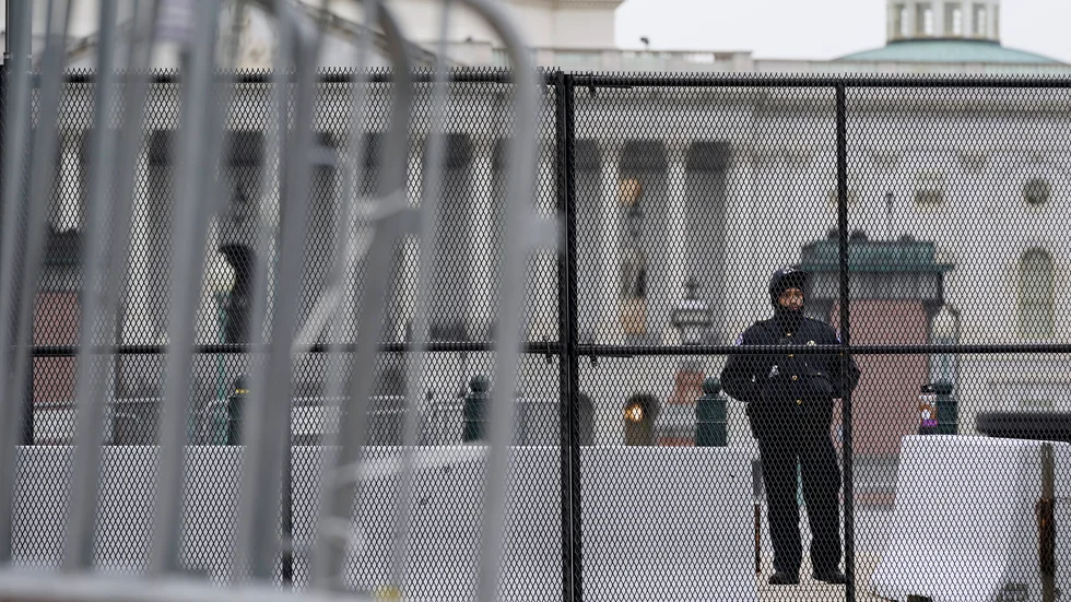 En polisman vaktar ett avspärrat Kapitolium i Washington DC, efter stormningen förra veckan. Nödläge har utlysts i staden inför Joe Bidens installation den 20 januari.