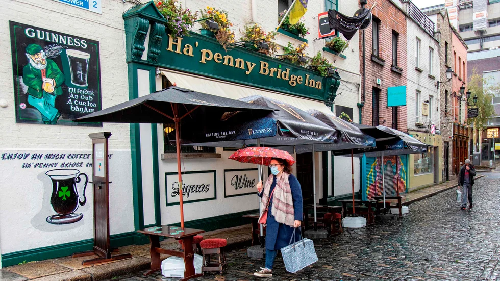 En kvinna passerar en nedstängd pub i Irlands huvudstad Dublin på måndagen.