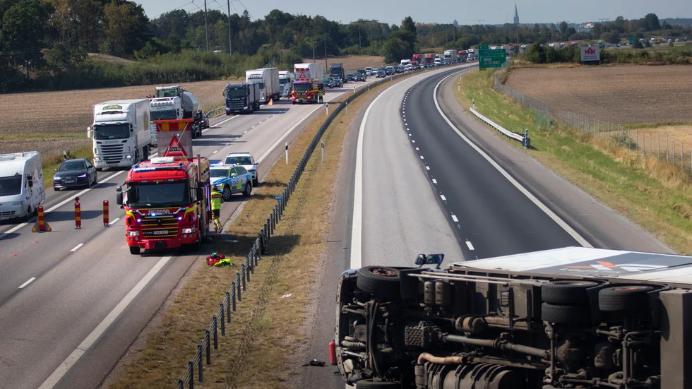 Lastbilen välte efter kollisionen med en personbil och ett brofundament och lade sig på sidan.