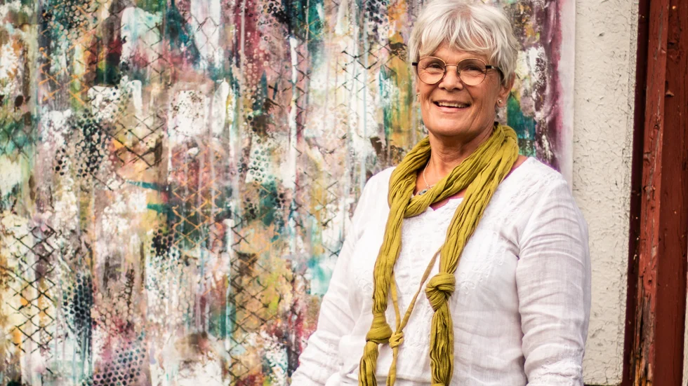 Maria Johansson brevid ett av hennes konstverk.