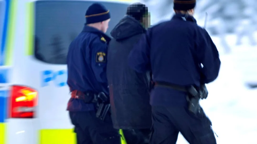 En av de gripna inbrottstjuvarna förs bort av polis. Tre av dem har nu anhållits, medan den yngste - bara 16-17 år gammal - har släppts.