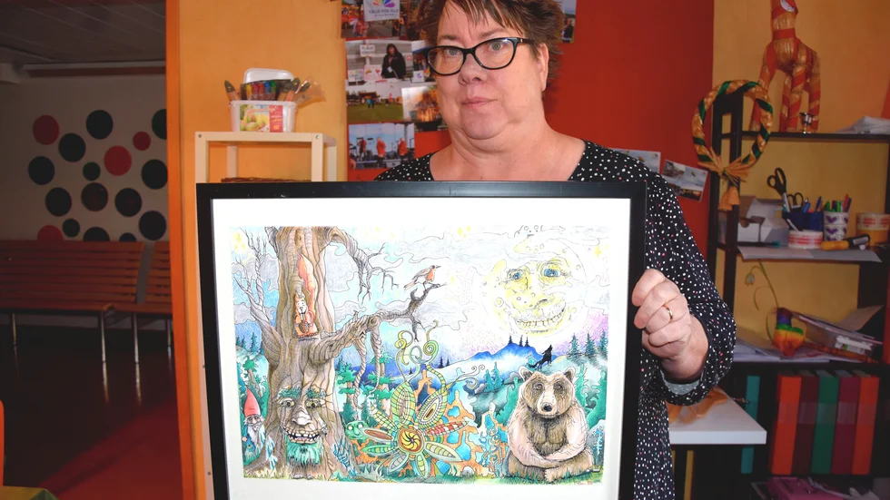 Cecilia Lindgren Parviainen visar "En helt vanlig kväll under fullmånens sken" av Robin Nyström, som är en av tavlorna som auktioneras ut.
