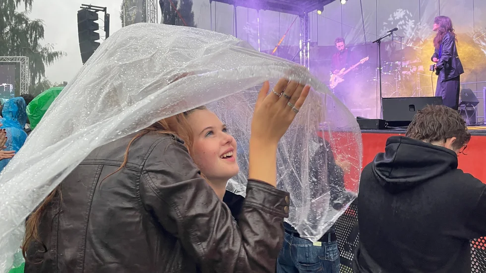 Klara Falck gömmer sig under en poncho tillsammans med Signe Lundgren och Kerstin Sundberg under Höks spelning.