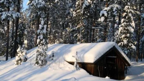Snön ligger djup över den gamla förrådsbyggnaden vid Piteälven.