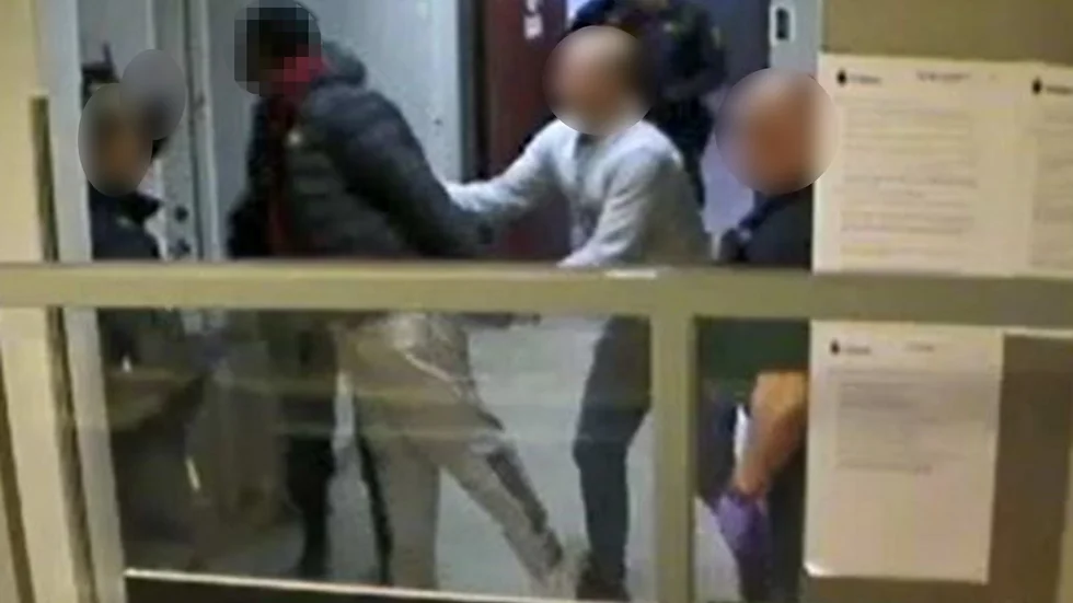 Bilden visar 18-åringen när han lutar sig nära en polis och spottar honom i ansiktet.