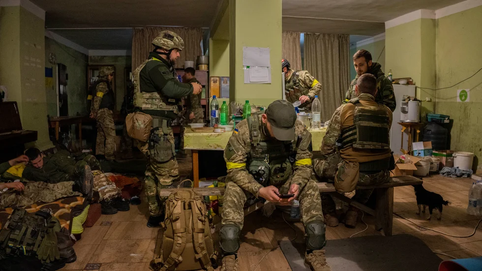 Ukrainska nationalgardet samlas i ett hus i en by utanför Charkiv, som nyligen befriats från ockupation.