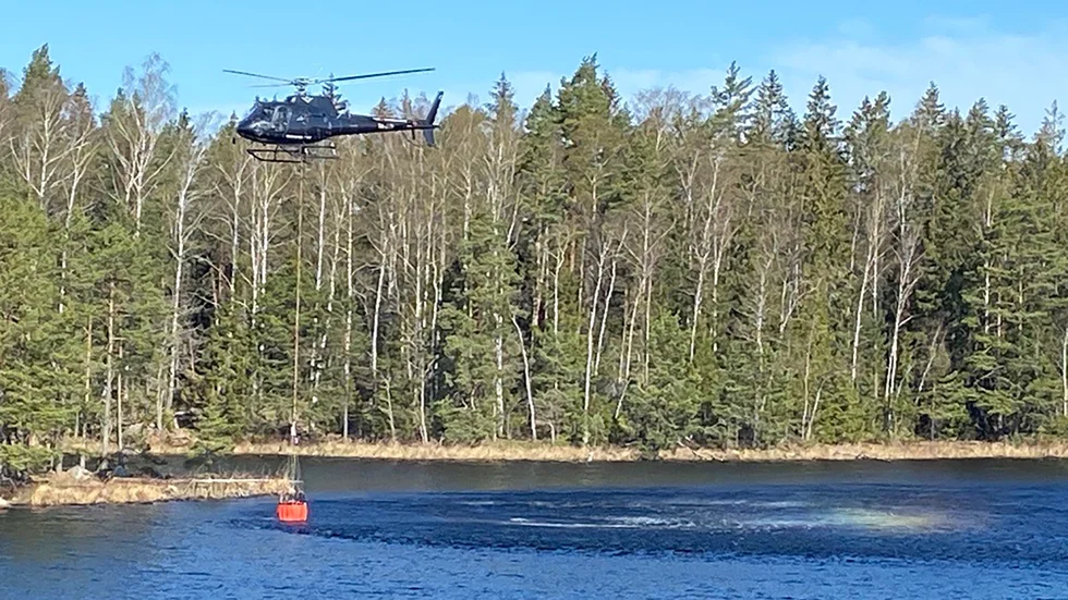 Skogsbranden vid Finnsjön bekämpas med vattenbombning från helikopter.