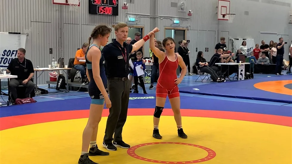 Leah Acars arm höjs i luften efter hennes triumf.