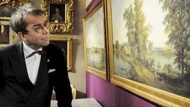 Knut Knutsson på Uppsala auktionskammare framför de två målningarna av Elias Martin.
