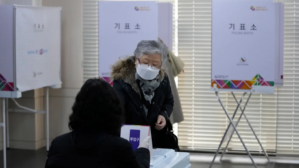 En väljare lägger sin röst i valurnan i en vallokal i Sydkoreas huvudstad Seoul på onsdagen.