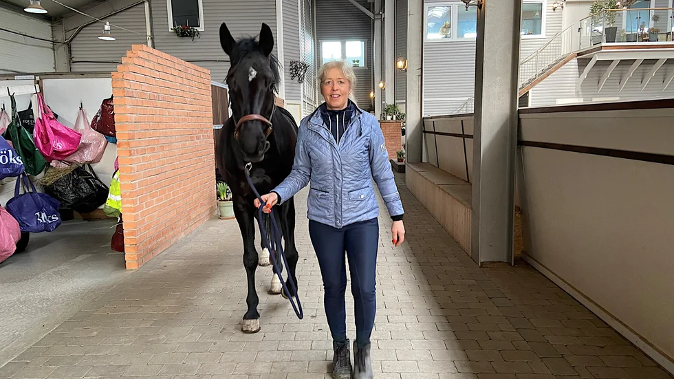 Lotta Hadenius som äger och driver Smedby gård sen 2015 valde direkt att satsa och utöka verksamheten. Här med hästen Awa i gången mellan det toppmoderna stallet och ridhuset.