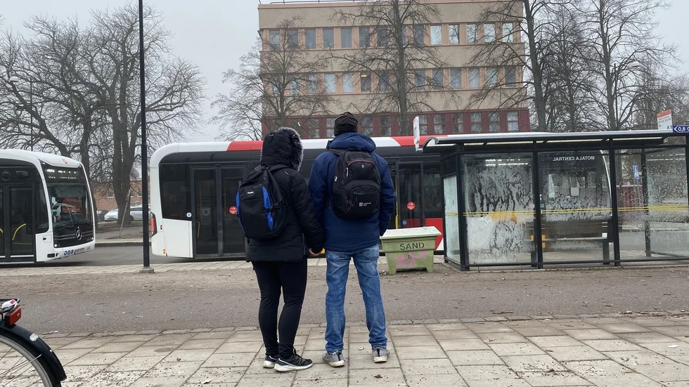 Ett par håller varandras händer under den tysta minuten i Motala.