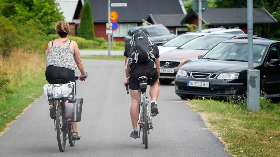 Magnus Pettersson och Elisabeth Pettersson cyklar hem från Jogersö där bilarna har använt en del av cykelbanan för att parkera.