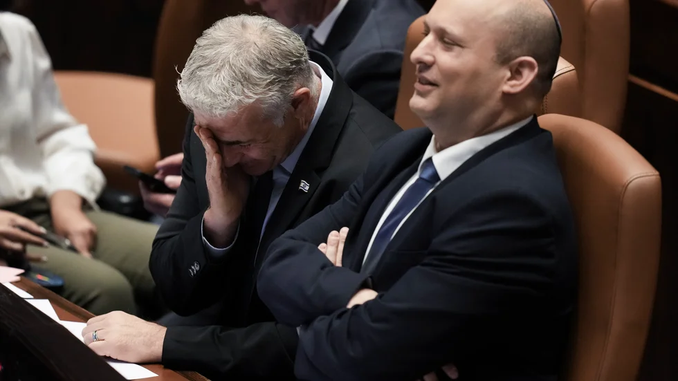 Avgående premiärminister Naftali Bennet, tillträdande premiärminister för övergångsperioden Yair Lapid, i Knesset inför omröstningen.
