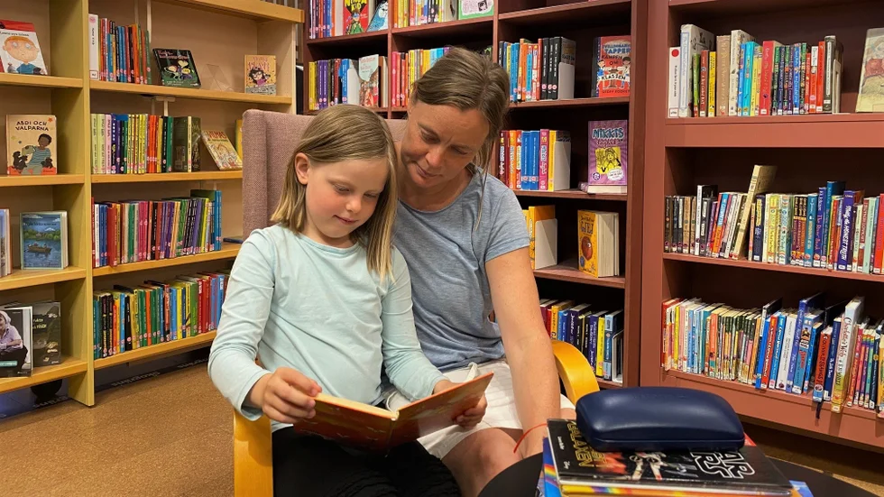 Leia Engström och Linda Engström läser boken Leia fastnat för på Stadsbiblioteket. 