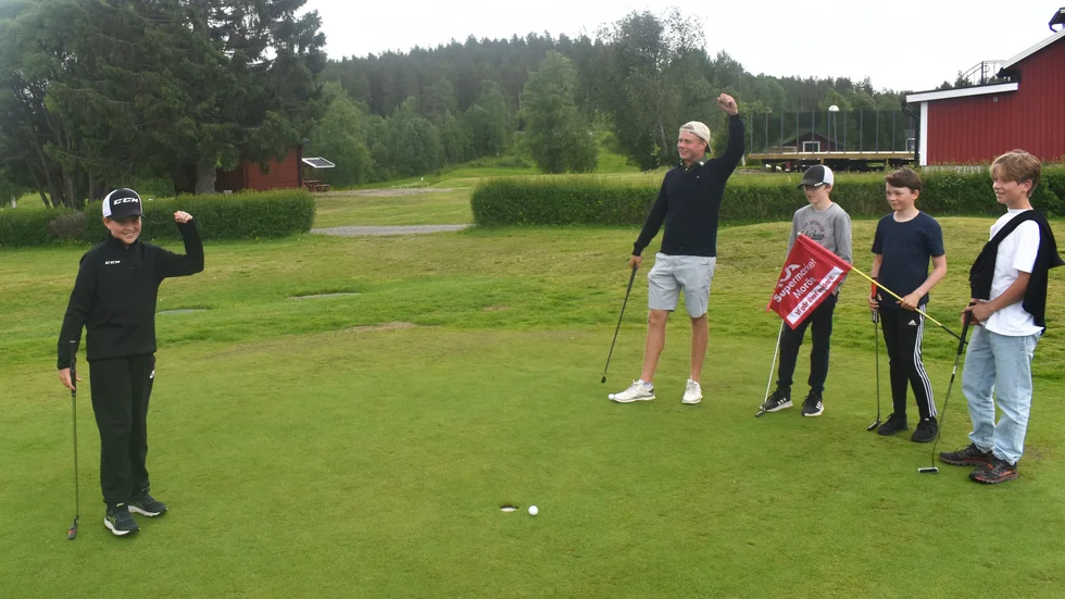 Charlie Hedström puttar, påhejad av sina kompisar.