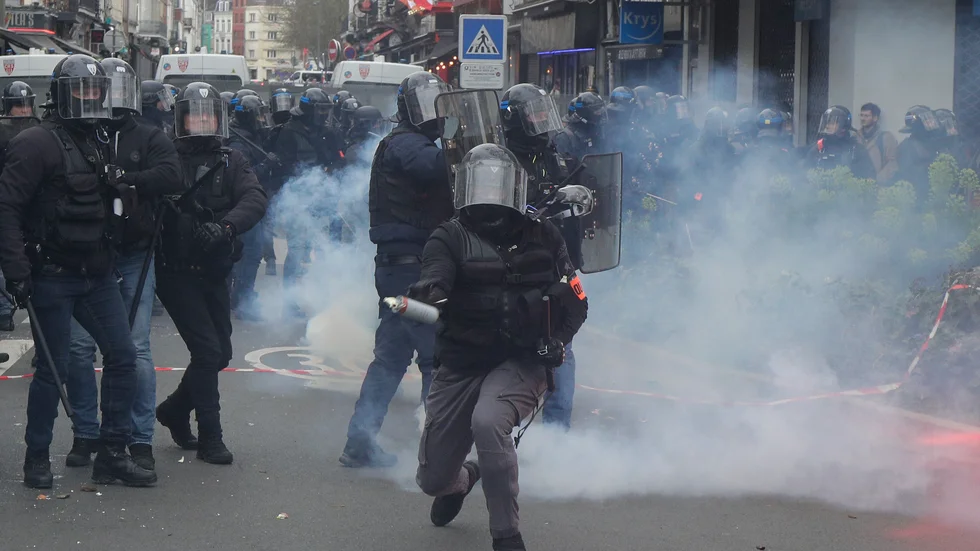 En polis förbereder sig för att kasta en tårgas under demonstrationen i Lille.