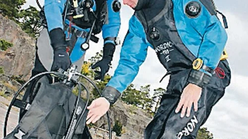 Andreas Will tar på sig västen med luftflaskan. Markus Brorsson väntar på att få göra parkontrollen. Molnen skingrar sig och blå himmel syns lagom till dyket!