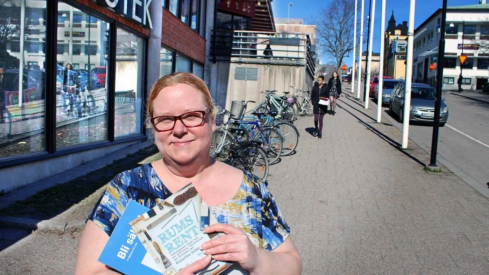 Bibliotekarie Marie-Louise Wammar på Motala bibliotek flaggar för den pågående bokinsamlingen inför bokbytardagen den 23 april. Böckerna på bilden kommer dock inte från insamlingen.