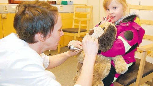 Doktor Helena Bäckström undersöker hunden Hunden, som sitter i Hilda Tsakiridis knä.