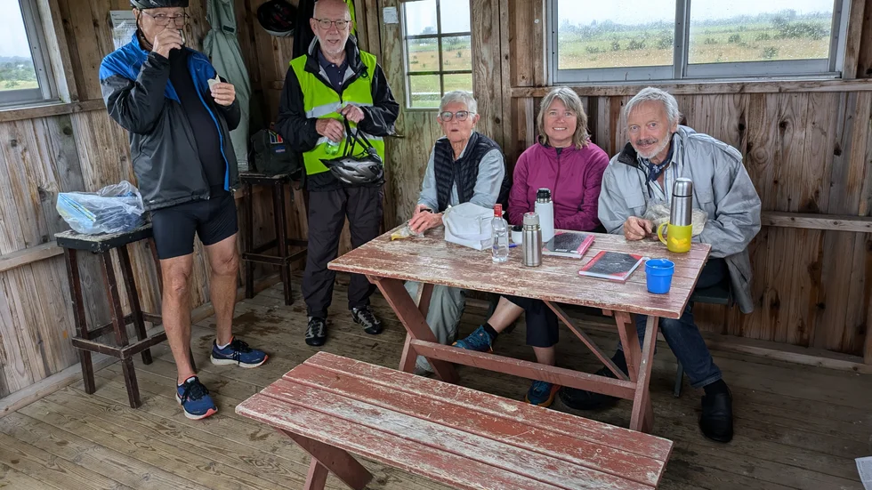 Några av Cykelfrämjandet Gotlands medlemmar tar en fika i skydd för regnet. 
