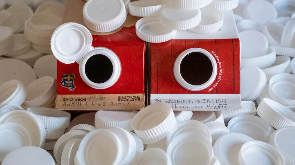 Mjölkförpackning med och utan fastsittande plastlock. Arkivbild.