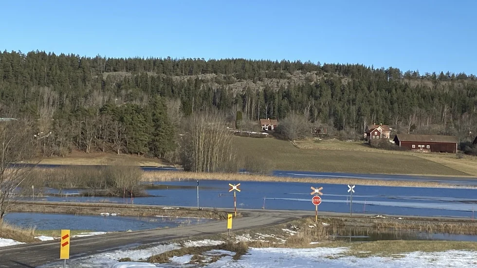 Vid järnvägsövergången i Gruvdalen är det ordentligt blött på båda sidor om spåret och vägen. Tjustbanan.
