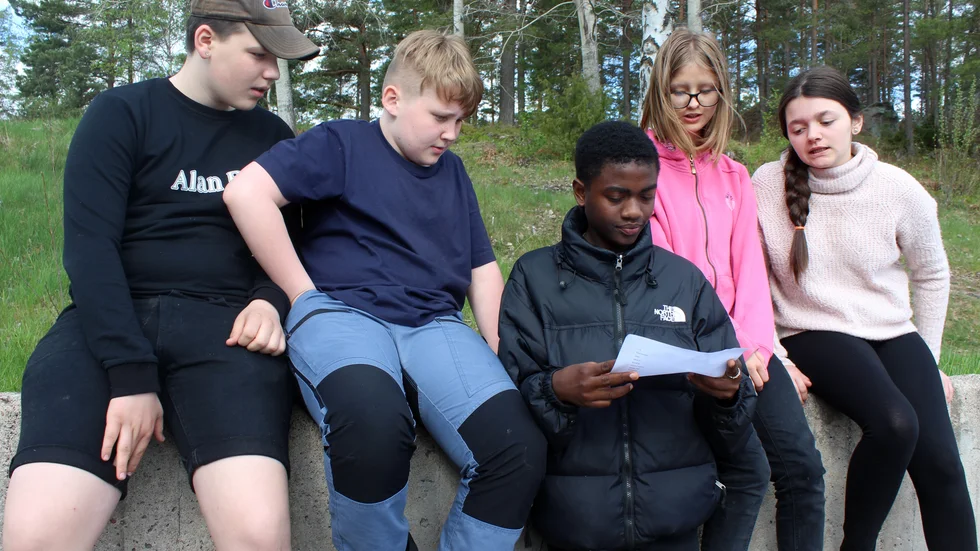 Nyhemseleverna Wilmer Karlsson, Isak Nilsson, Hakim Juma, Marie-Louise Ruud och Saga Persson läser upp orden som de skickade in till nya sången om Finspång.