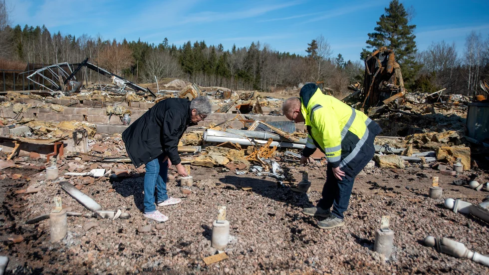 Carola och Anders Johansson vid resterna av det som finns kvar av det totalförstörda huset.