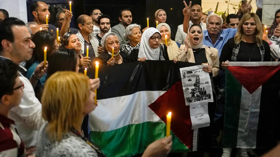 Människor håller tända ljus och palestinska flaggor vid en minnesstund för den dödade journalisten Shireen Abu Akleh. Bilden togs den 17 maj, en knapp vecka efter det att hon skjutits ihjäl i samband med en israelisk räd i Jenin.