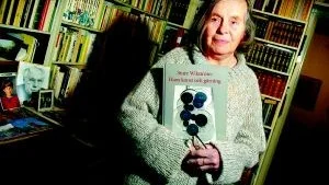 Mot Paris. Konstnären Ann-Marie Ekbom Wikström trivs i sitt bibliotek. Här med en bok om sin framlidne man Sture Wikström. Under maj månad visar Ann-Marie konst på Salon de Mai i Paris.  Foto: Anders Steiner