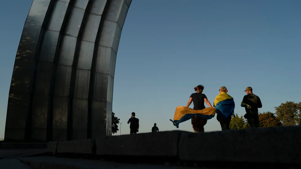 Attacken mot järnvägsstationen kom på onsdagen, då Ukraina högtidlighöll sin självständighetsdag. På bilden syns människor med ukrainska flaggor som i Kiev går förbi ett monument från sovjettiden.