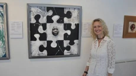 Vissångerskan Petra Haraldsson vid målningen Pussel av Leja-Lena Lindén Jacobsson som inspirerats av låten med samma namn.Foto: Rikard Ekholm