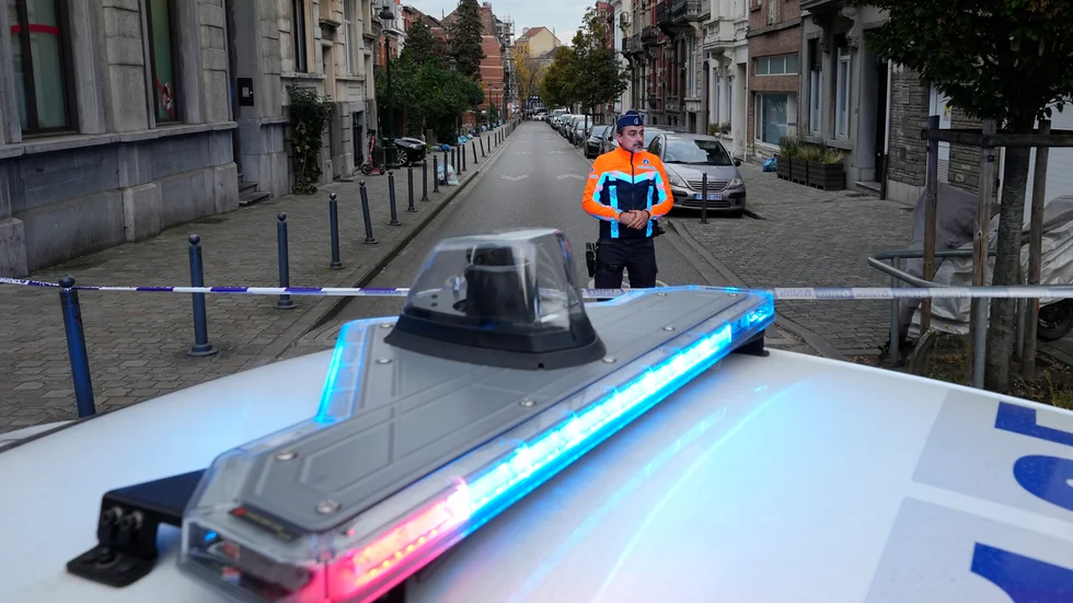 Belgisk polis vid avspärrningar i närheten av platsen där den misstänkte gärningsmannen sköts till döds under tisdagsmorgonen